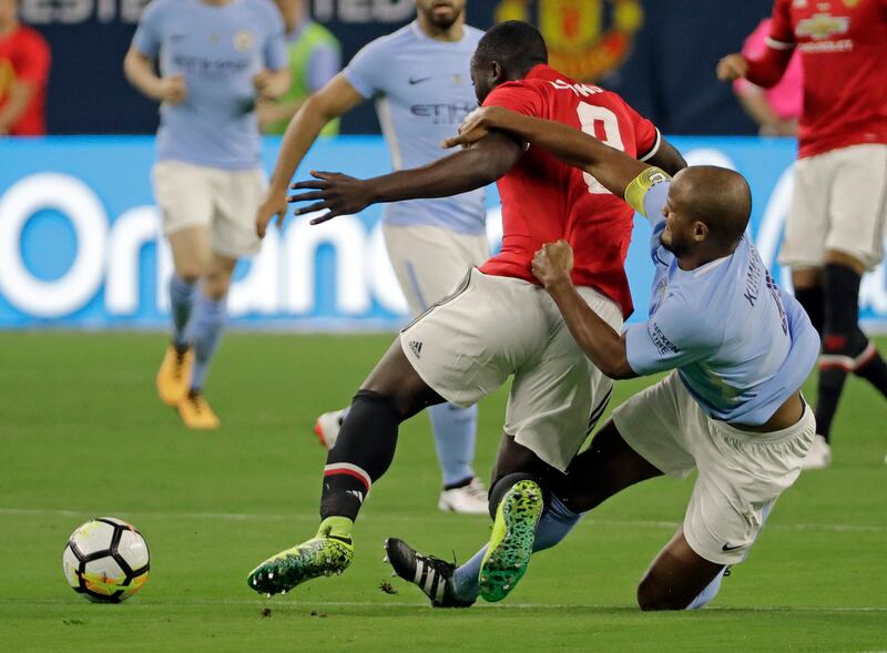 Manchester City's Vincent Kompany, right, tackles Manchester United's Romelu Lukaku, left. David J. Phillip / AP Photo