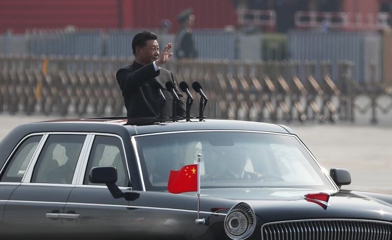 Chinese President Xi Jinping waves as he rides in an open-top limousine. EPA