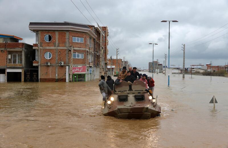 Military vehicles rescue people after flash flooding around the northern city of Aq Qala. AP Photo