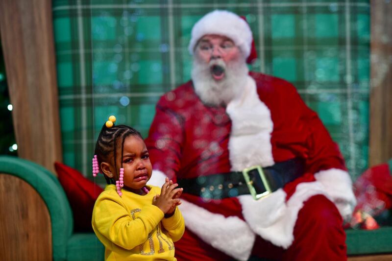 Majesty Davis, 3, cries while visiting Santa Claus, who sits behind a plexiglass divider, at the Willow Grove Park Mall in Willow Grove, Pennsylvania. Reuters