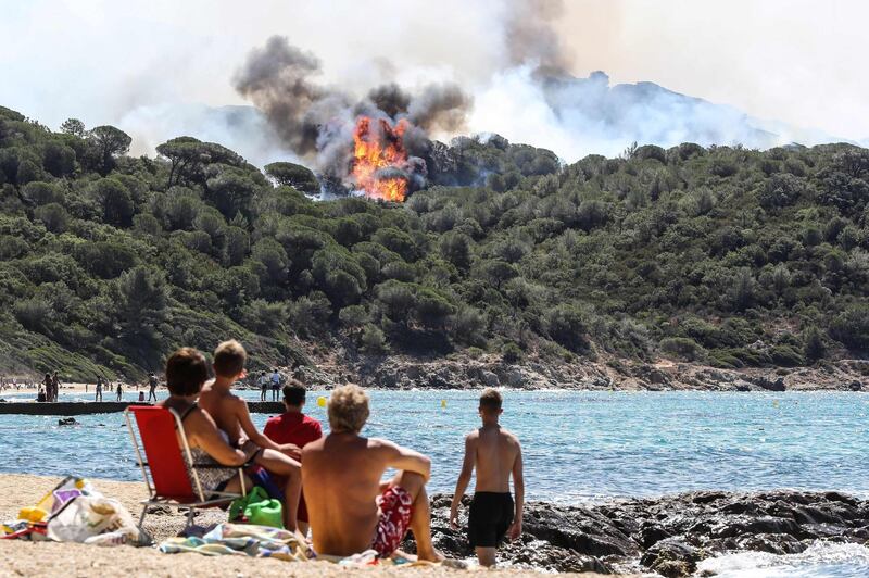 Beachgoers watch a forest fire from afar in La Croix-Valmer, near Saint-Tropez, France. Valery Hache / AFP Photo / July 25, 2017