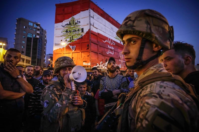 Lebenese soldiers keep watch as several hundred people protest in the northern city of Tripoli on April 17, 2020 despite the country's coronavirus lockdown, marking six months since the country was rocked by mass rallies over government corruption and economic hardships. AFP