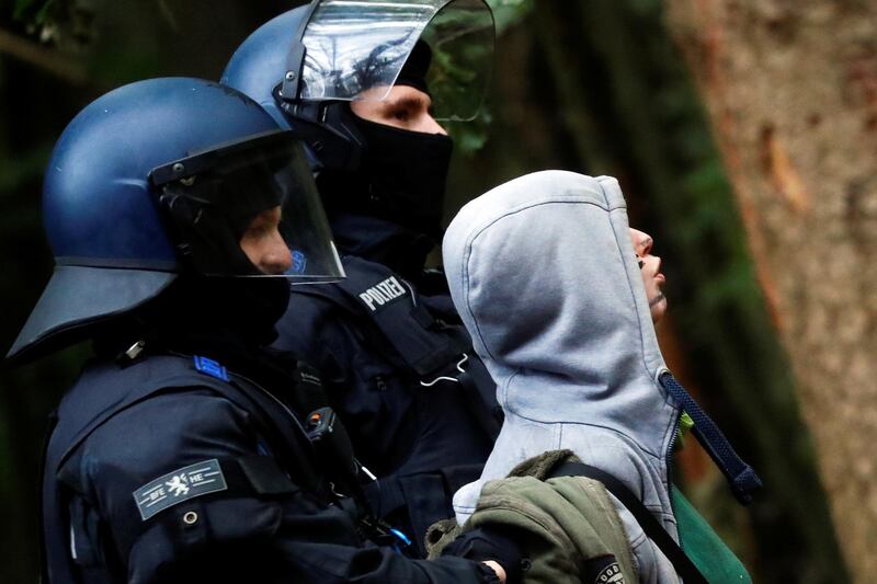 An environmental activist reacts while being detained by police officers during a protest against the expansion of the A49 motorway, in a forest near Stadtallendorf, Germany. Reuters