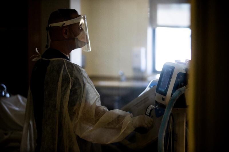 epa08992690 A caregiver takes care of a Covid-19 patient in his ICU (Intensive care Unit) room at the Sharp Chula Vista Medical Center, amid coronavirus pandemic in Chula Vista, South of San Diego, California, USA, 05 February 2021 (issued on 06 February 2021). Located by the Mexican border, the hospital sees a lot of Mexican nationals crossing the border seeking care for Covid-19.  EPA/ETIENNE LAURENT