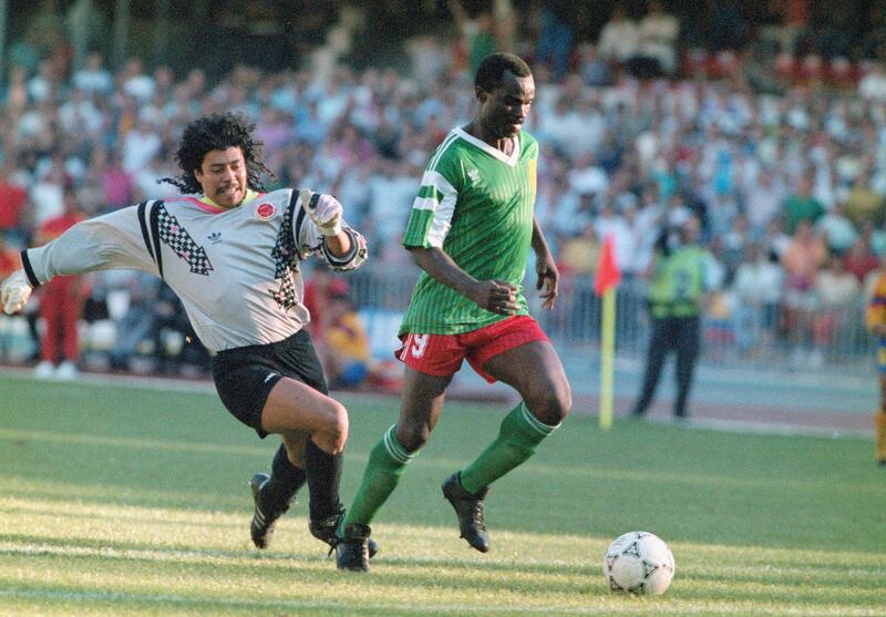 NAPLES, ITALY - JUNE 23:  Cameroon striker Roger Milla walks the ball into the empty net to score the winning goal after dispossesing Colombian goalkeeper Rene Higuita (l) of the ball mid pitch during the Second phase match between Cameroon and Colombia on June 23, in Naples, Italy. (Photo by Allsport/Getty Images)