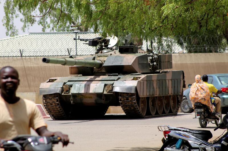 People drive past a Chad army tank near presidential palace, as fighters from the rebel Front for Change and Concord in Chad (FACT) appeared to be moving toward the capital according to the United States, in N'djamena, Chad April 19, 2021. Reuters