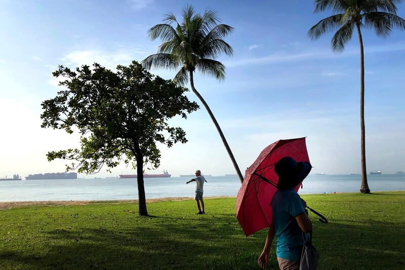 An elderly man exercises, while a woman is out on a stroll at East Coast Park in Singapore.  Wong May-e / AP Photo