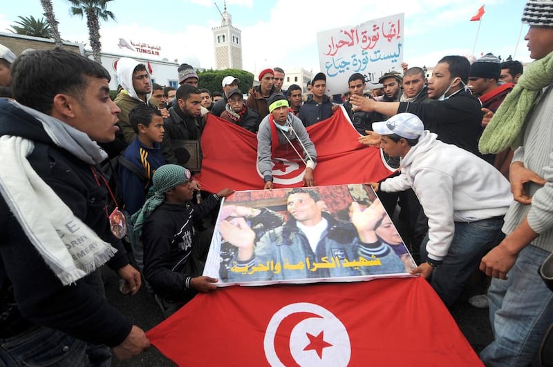 Kasserine residents protest with a Mohamed Bouazizi poster and Tunisian flag in front of the government palace in Tunis. Security forces went on their worst rampage in Kasserine and Thala. Fethi Belaid / AFP

