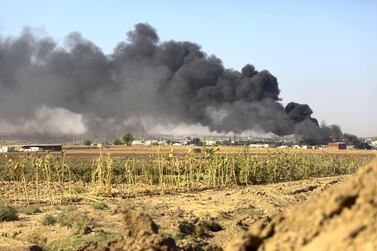 Smoke billows from the border town of Ras Al Ain, under assault by Turkish forces and Turkish-backed rebels. Nazeer Al Khatib / AFP