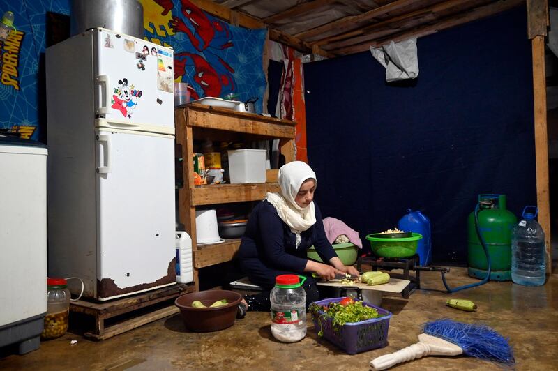 A teenaged Syrian refugee prepares Iftar hours before breaking day-long Ramadan fast at her tent inside a refugee camp in Akkar, Lebanon. EPA