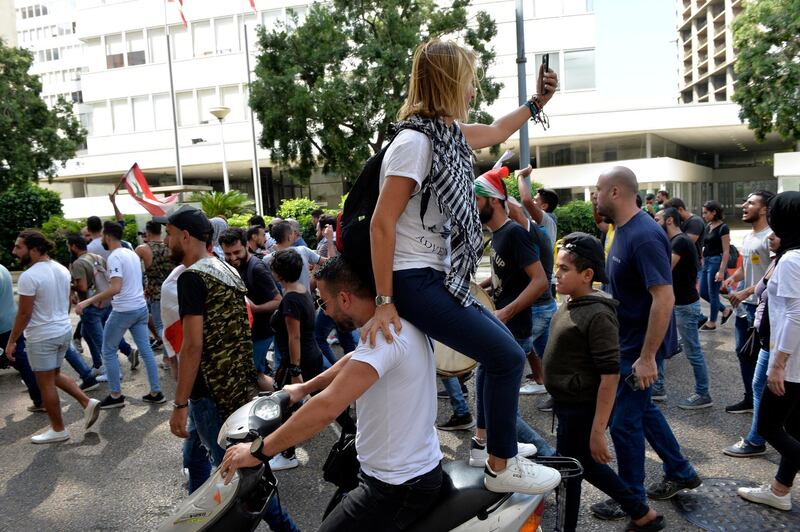 A woman takes pictures during the protest in Beirut.  EPA