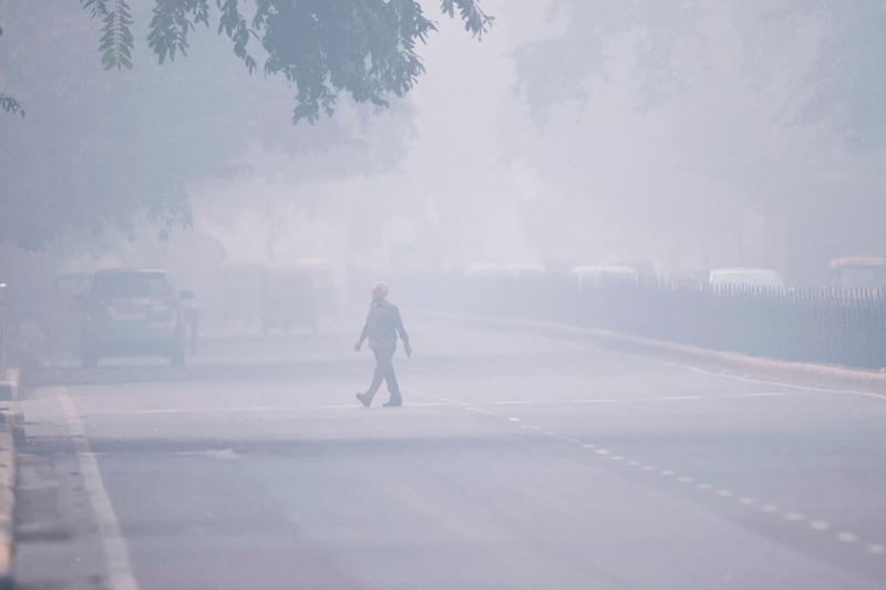 TOPSHOT - A man crosses a street in smoggy conditions in New Delhi on November 4, 2019. Millions of people in India's capital started the week on November 4 choking through "eye-burning" smog, with schools closed, cars taken off the road and construction halted. / AFP / Jewel SAMAD
