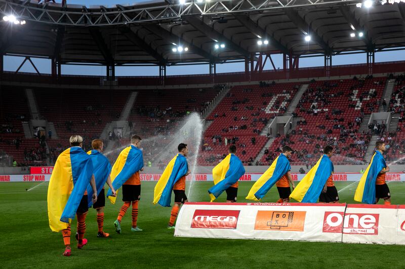 Shakhtar Donetsk players carry the Ukrainian flag before their football match against Olympiakos in Piraeus, near Athens. AP