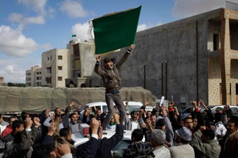 Pro-Qaddafi supporters stage a small rally, during a government-provided tour for foreign media to see trucks carrying food aid which according to the government was headed to Benghazi.