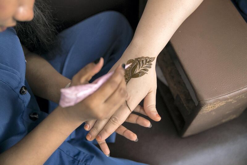 ABU DHABI, UNITED ARAB EMIRATES - AUGUST 16, 2018. 

Chathurika Samanmali, 25, puts henna on Mafia Shabbir, 28, her colleague, at Abeer Beauty & Henna salon in Baniyas.

(Photo by Reem Mohammed/The National)

Reporter: Anna Zacharias
Section:  NA