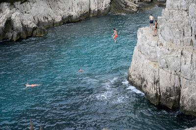 Young people jump from cliffs at the calanque de Sugiton in the Parc national des calanques in Marseille, southern France, on June 24. AFP