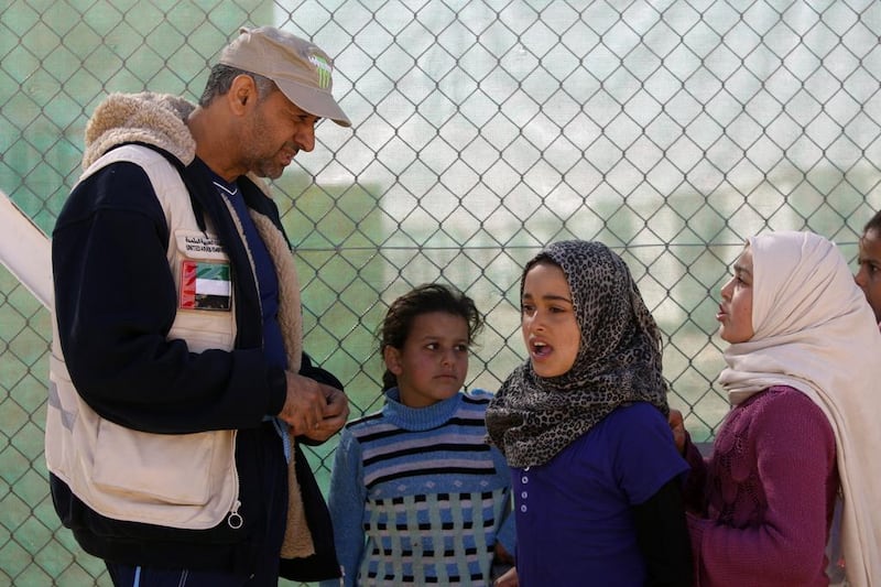 Syrian refugee children talk to a volunteer at the Emirati-Jordanian camp for Syrian refugees, run by the ERC at Mrajeeb Al Fuhud. Salah Malkawi for The National 