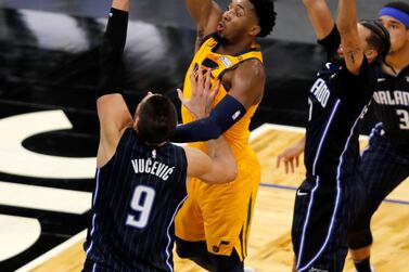 Utah Jazz guard Donovan Mitchell shoots under pressure from Orlando Magic centre Nikola Vucevic (9) and guard Michael Carter-Williams (7). AP