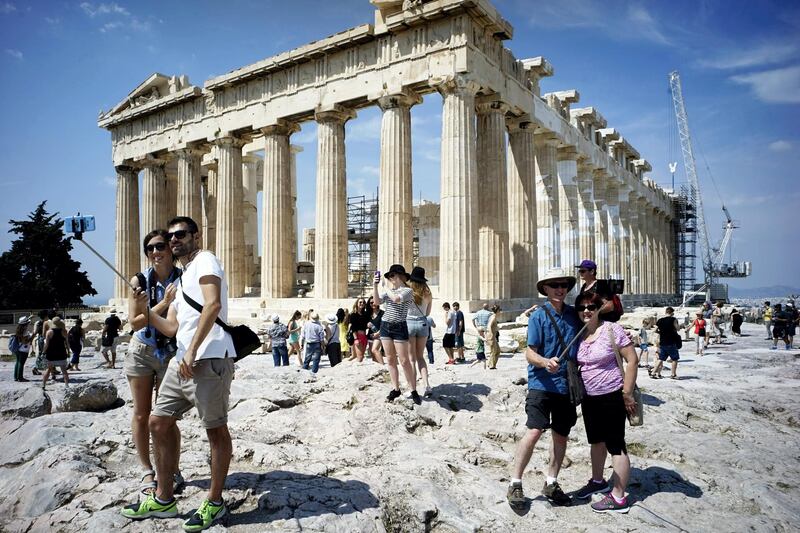 ATHENS, GREECE - JUNE 30: Tourists visit the ancient Acropolis hill, with the ruins of the fifth century BC Parthenon temple on June 30, 2015 in Athens, Greece. Greek voters will decide in a referendum next Sunday on whether their government should accept an economic reform package put forth by Greece's creditors. Greece has imposed capital controls with the banks being closed until the referendum and a daily limit of 60 euros has been placed on cash withdrawals from ATMs. (Photo by Milos Bicanski/Getty Images)