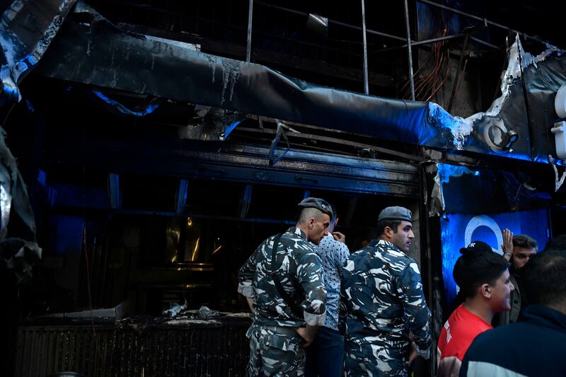 Police and residents gather outside the burnt restaurant in Beirut, Lebanon. EPA