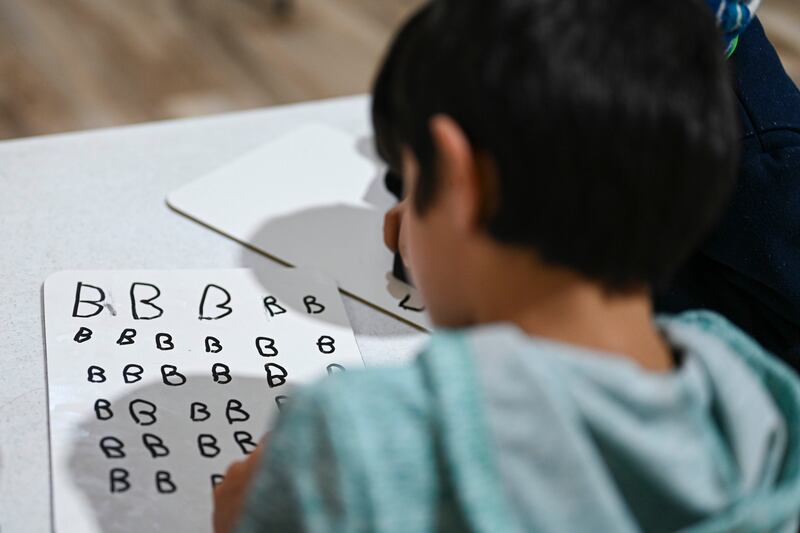 An Afghan pupil writes her ABCs during the first day of community-based education in Liberty Village, Joint Base McGuire-Dix-Lakehurst, New Jersey. Photo: Sgt Rion Ehrman / US Air Force