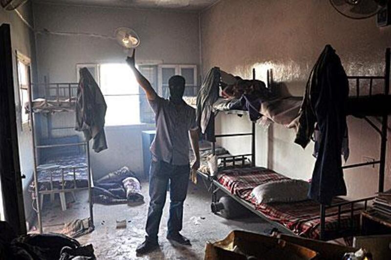 A masked opposition fighter poses inside the Shaar district police station in Aleppo yesterday.