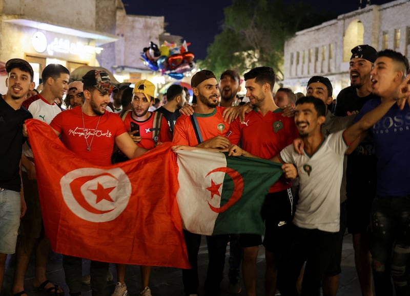 Arab fans with Tunisia and Algeria flags cheer at a popular tourist area in Souq Waqif. Reuters