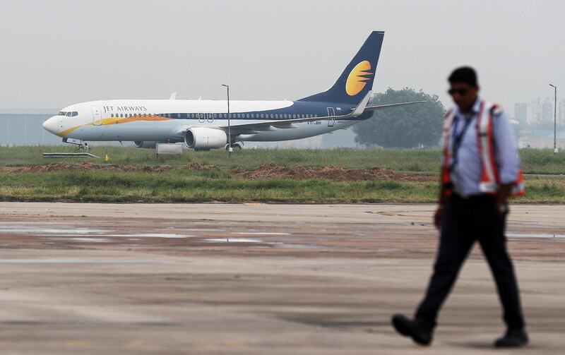 FILE PHOTO: A Jet Airways Boeing 737-800 passenger plane moves on the runway as a man walks past at an airport in New Delhi, India, August 27, 2018. REUTERS/Adnan Abidi/File Photo