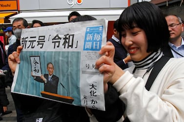 A woman holds a copy of the Mainichi Shimbun newspaper reporting the name of new era “Reiwa” in Tokyo. AP