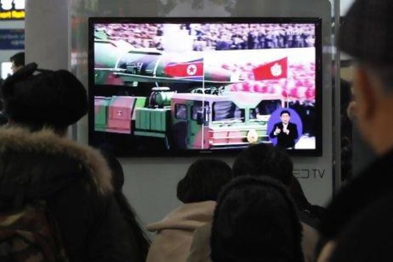 People watch a TV file footage of a North Korean rocket carried during a military parade, at Seoul Railway Station, South Korea.