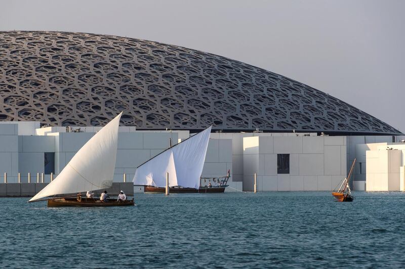 Abu Dhabi, United Arab Emirates, November 11, 2017:    A traditional dhow sails during the past the Louvre Abu Dhabi during the opening day on Saadiyat Island in Abu Dhabi on November 11, 2017. Christopher Pike / The National

Reporter: James Langton, John Dennehy
Section: News