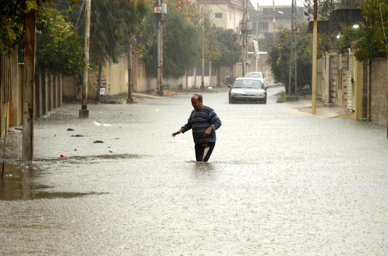 An Iraqi man walks amid a flooded street in Mosul, northern Iraq. According to media reports, the Nineveh provincial council declared an emergency and decided to shut the university and schools in Mosul because of floods that swept most of the city.  EPA