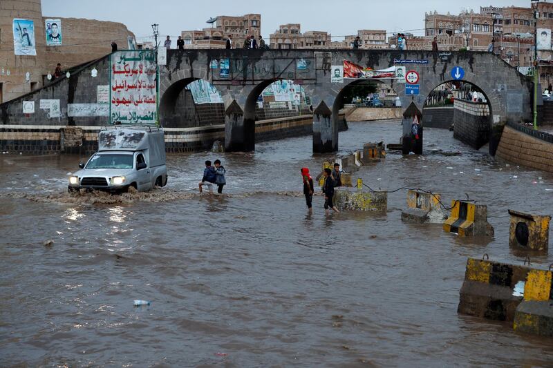 A vehicle drives through a flooded street following heavy rains in the old quarter of Sana'a, Yemen. Heavy rains and associated floods through Yemen have left at least 16 people dead and damaged dozens of homes and roads.  EPA