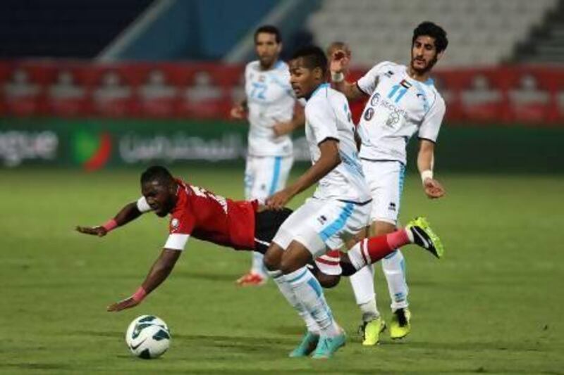 ABU DHABI , UNITED ARAB EMIRATES - April 15 , 2013 : Ismaeel Al Hamadi ( no 7 in red ) of Al Ahli and Mohammed Fawzi ( no 8 in white ) of Bani Yas in action during the Etisalat Pro - League football match between Bani Yas vs Al Ahli at Baniyas stadium in Abu Dhabi. ( Pawan Singh / The National ) For Sports