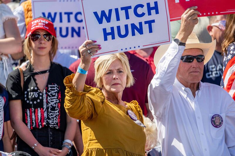 Supporters held signs saying 'WITCH HUNT' as Mr Trump attacked the multiple investigations against him. Getty