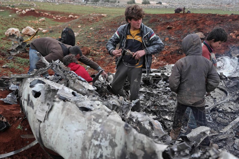 Syrians inspect the wreckage of a military helicopter belonging to government forces after it was shot down over the western countryside of Aleppo province on February 14, 2020. AFP