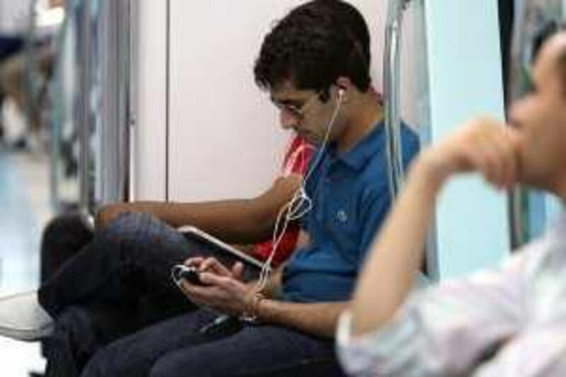 DUBAI, UNITED ARAB EMIRATES - FEBRUARY 8:  A passenger listens to headphones while riding on the Metro in Dubai on February 8, 2010.  (Randi Sokoloff / The National)  For News story by Eugene