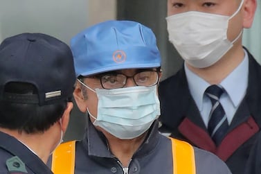Former Nissan chairman Carlos Ghosn (C) is escorted as he walks out of the Tokyo Detention House. AFP