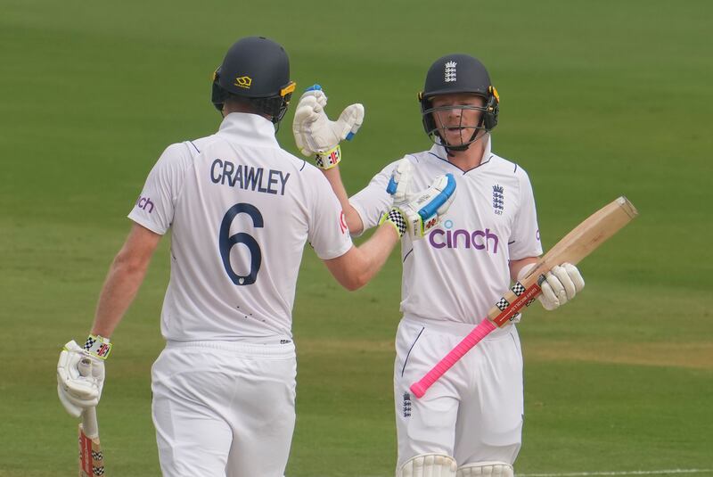England's Ollie Pope congratulates Zak Crawley after the opener reached ihs half-century. AP