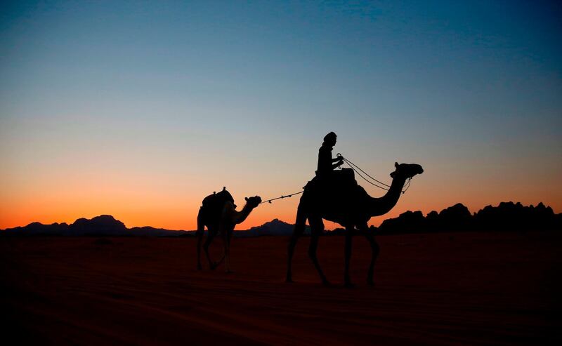 A Bedouin rides a camel as the sun sets in the southern Jordanian desert of Wadi Rum. Thomas Coex/AFP