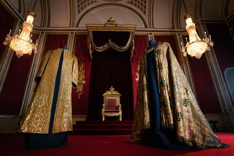 The Supertunica, left, and the Imperial Mantle on display in the throne room at Buckingham Palace