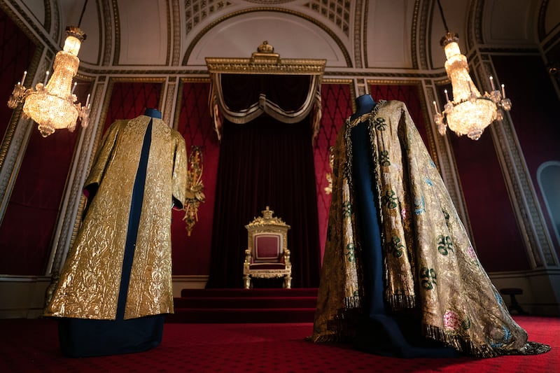 The Supertunica, left, and the Imperial Mantle on display in the throne room at Buckingham Palace