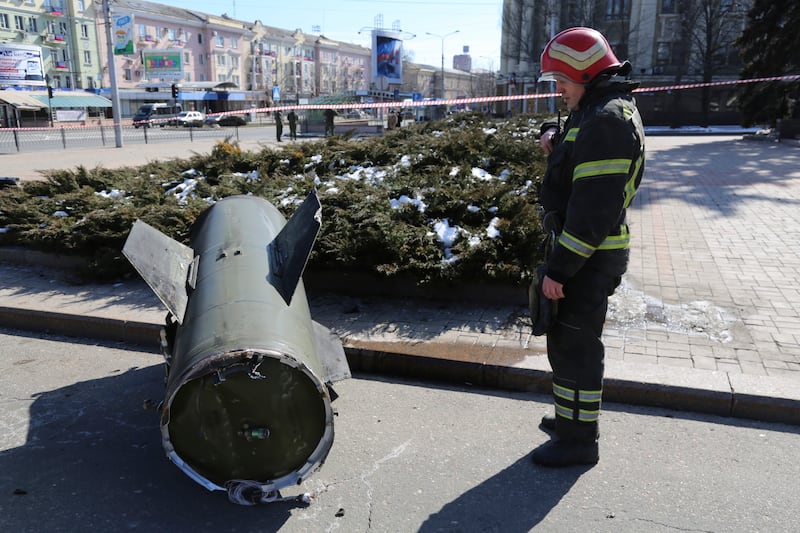 A firefighter looks at a section of a Ukrainian Tochka-U missile on a street in the separatist Donetsk region. The Russian military said 20 civilians were killed by a ballistic missile launched by the Ukrainian forces. AP
