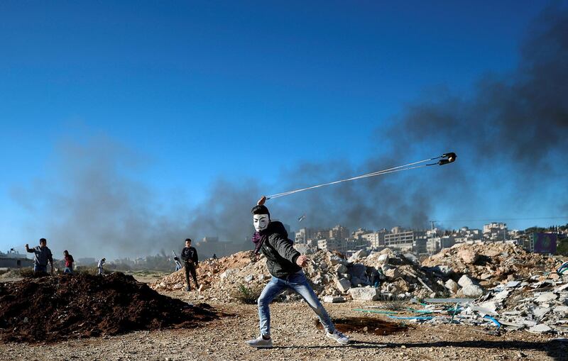 A Palestinian uses a sling to hurl stones during clashes with Israeli troops near the Jewish settlement of Beit El, near Ramallah.  Reuters