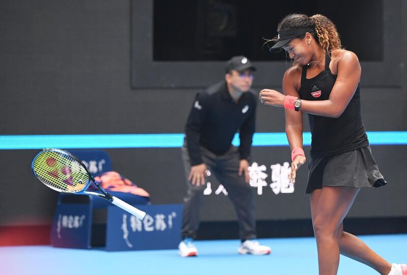 Naomi Osaka of Japan throws her racquet during her women's quarter-final match against Zhang Shuai of China at the China Open tennis tournament in Beijing on October 5, 2018. / AFP / GREG BAKER
