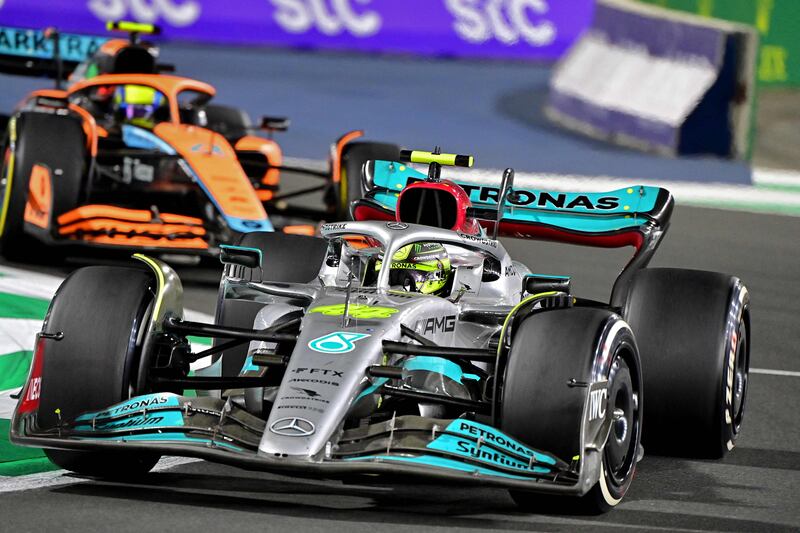 Mercedes' British driver Lewis Hamilton (foreground) and McLaren's British driver Lando Norris (background) drive during the 2022 Saudi Arabia Formula One Grand Prix at the Jeddah Corniche Circuit on March 27, 2022.  (Photo by ANDREJ ISAKOVIC  /  AFP)