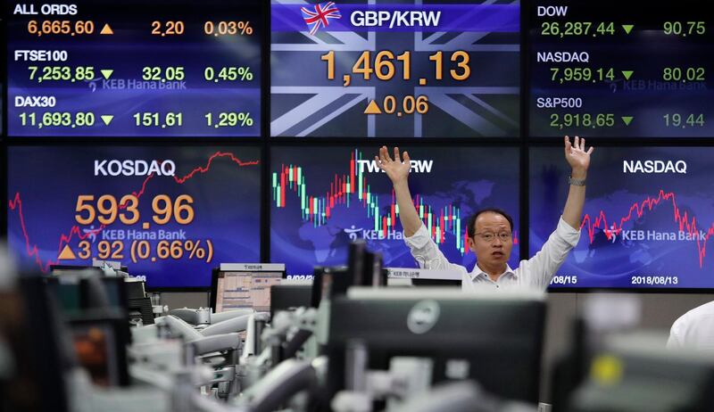 A currency trader gestures at the foreign exchange dealing room of the KEB Hana Bank headquarters in Seoul, South Korea, Monday, Aug. 12, 2019. Asian stocks gained Monday amid investor jitters the U.S.-China trade war might be worsening. (AP Photo/Ahn Young-joon)