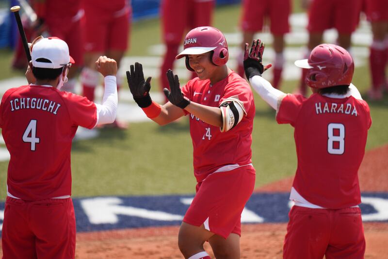 Japan's Minori Naito, centre, celebrates with her teammates after hitting a two run home run.