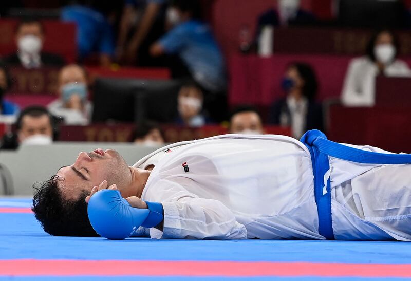 Iran's Sajad Ganjzadeh lays motionless after an injury in the men's kumite +75kg final against Saudi Arabia's Tareg Hamedi.