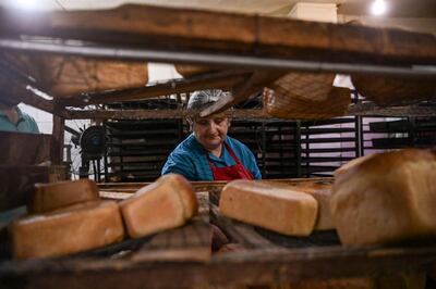 A woman makes bread at a bakery in the city of Stepanakert, that works 24 hours a day to offer free bread to the remain residents and delivering - when needed - to the cities of Martuni and Martakert, on October 21, 2020, during the ongoing fighting between Armenia and Azerbaijan over the breakaway region of Nagorno-Karabakh. / AFP / ARIS MESSINIS
